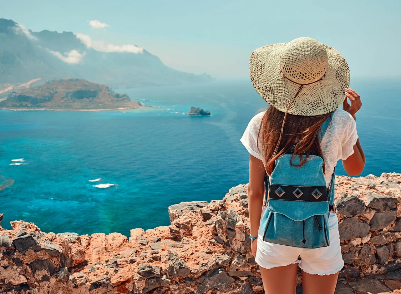 sunny seaside view with woman in woven hat 